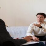 Patient sitting in front of a counselor on sofa.