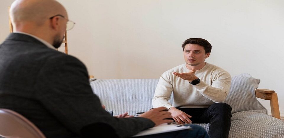 Patient sitting in front of a counselor on sofa.
